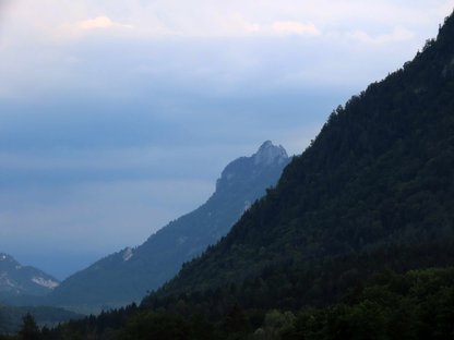 Ein Berg taucht hinter einem anderen Bergrücken auf