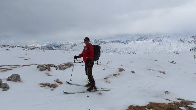 Skibergsteiger auf einem flachen, abgeblasenen Gipfel 