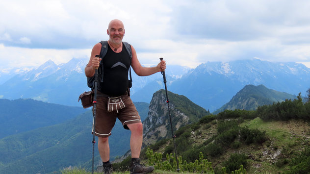 Bergsteiger mit Wanderstöcken an einem wolkigen Tag auf Berggipfel 