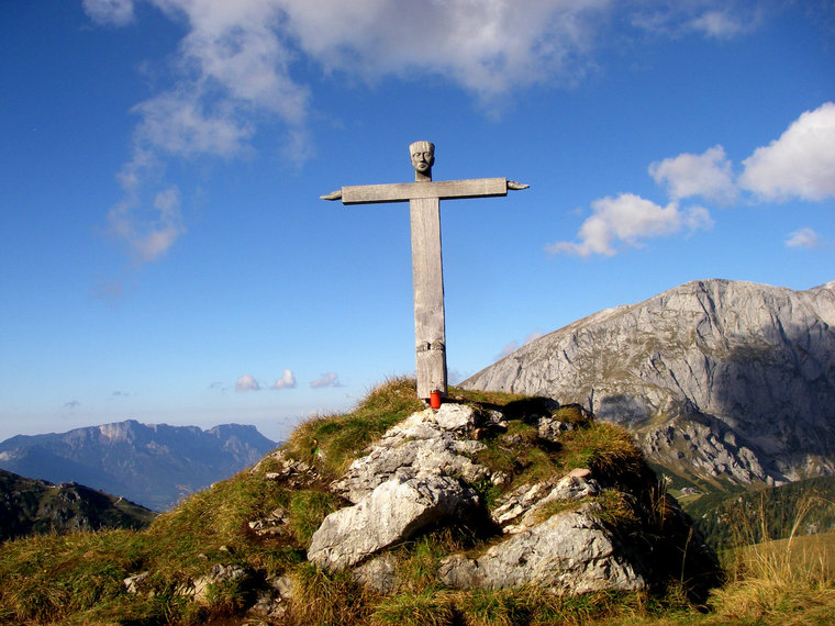 Außergewöhnliches Holzgipfelkreuz mit Kopf, Händen und Füßen an den Kreuzenden