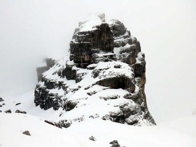 Wilder Felskoloss in alpiner Winterlandschaft