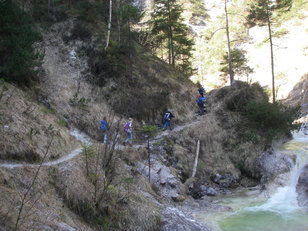 Kinder wandern an einem Bergbach entlang