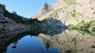 Klarer, spiegelnder Bergsee 