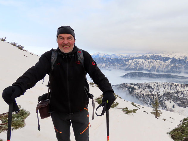 Skitourengeher auf einem, von Saharastaub eingefärbten Gipfelhang 