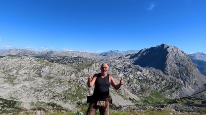 Bergwanderer am Gipfel vor wilder Berglandschaft