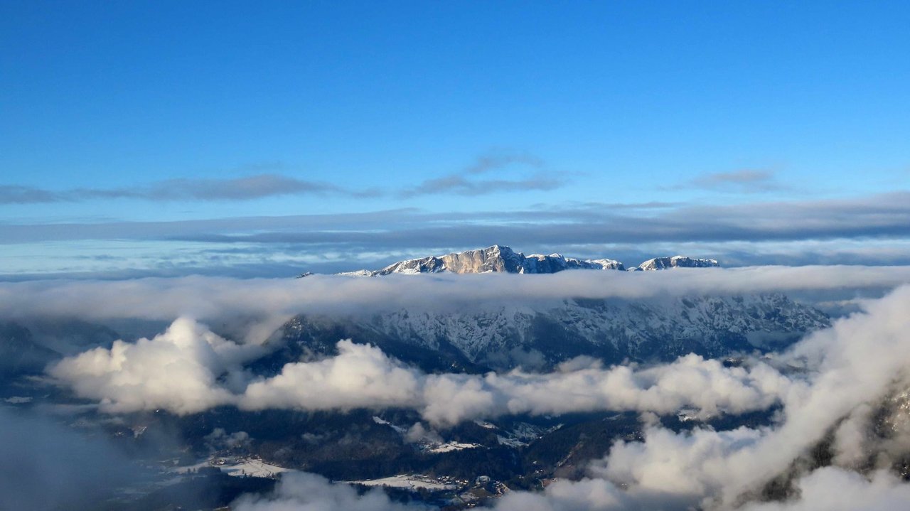 Plateauberg ragt aus mehrschichtigen Wolken heraus