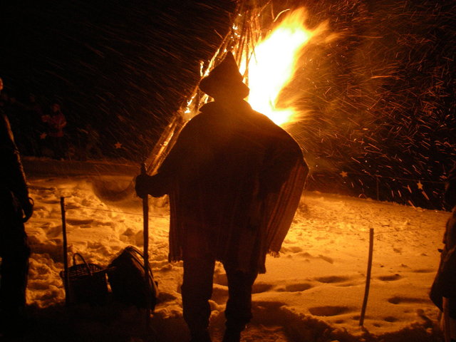 Mann mit Hut am Sonnwendfeuer