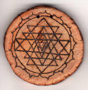 Sonnenbebrannte Holzscheibe mit Yantra im Lotus