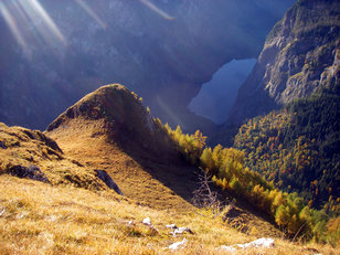 Grasiger Gipfel über einem tiefer gelegenen Bergsee