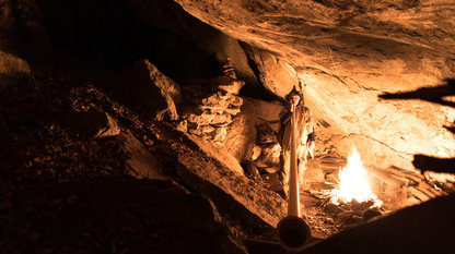 Alphornbläser in einer Höhle