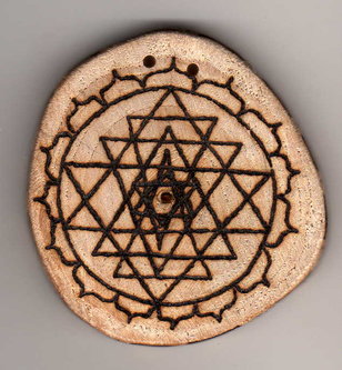 Sonnenbebrannte Holzscheibe mit Yantra im Lotus