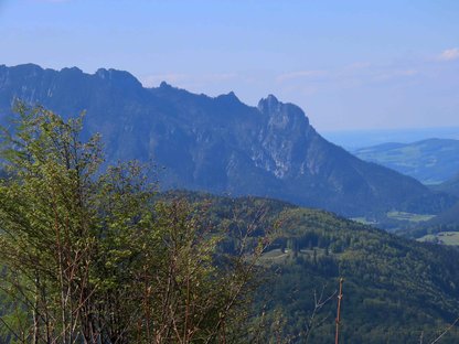 Ausblick zu einem Gebirgszug in dem die Silhouette einer Hexengestalt erkennbar ist