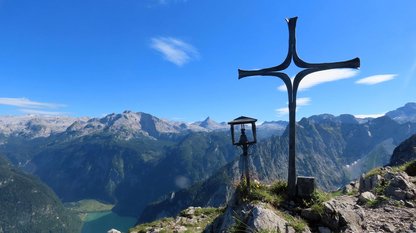 Eisernes Gipfelkreuz vor imposanter Bergkulisse