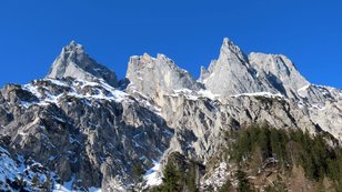 Schneebedeckte, wilde Felszacken über einem Bergsturzkar