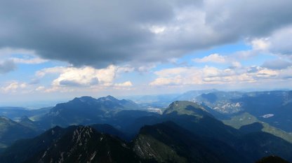 Dunkle Wolken über wilden Bergen