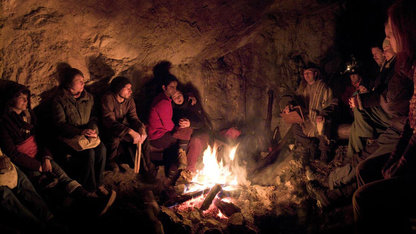 Leute in einer Höhle am Lagerfeuer