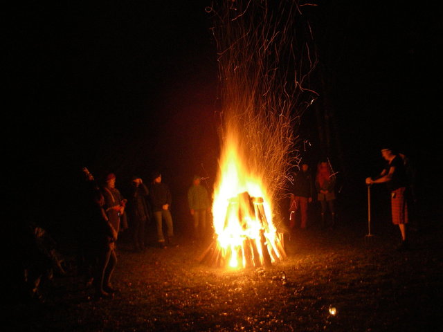 Ein Kreis von Menschen um ein sehr großes Feuer