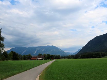 Asphaltierter Radweg führt auf einen markanten, breiten Berg zu