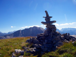 Steinmandl mit Hut in wilder Berglandschaft