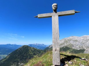 Ein sehr spezielles Holzgipfelkreuz mit Kopf, Händen und Füßen an den Enden