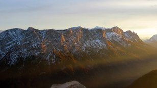 Goldene Abendsonnenstrahlen bei schneebedecktem Gebirge