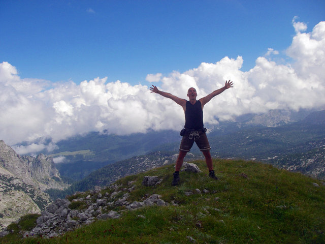 Mann mit ausgebreiteten Armen in Bergwelt